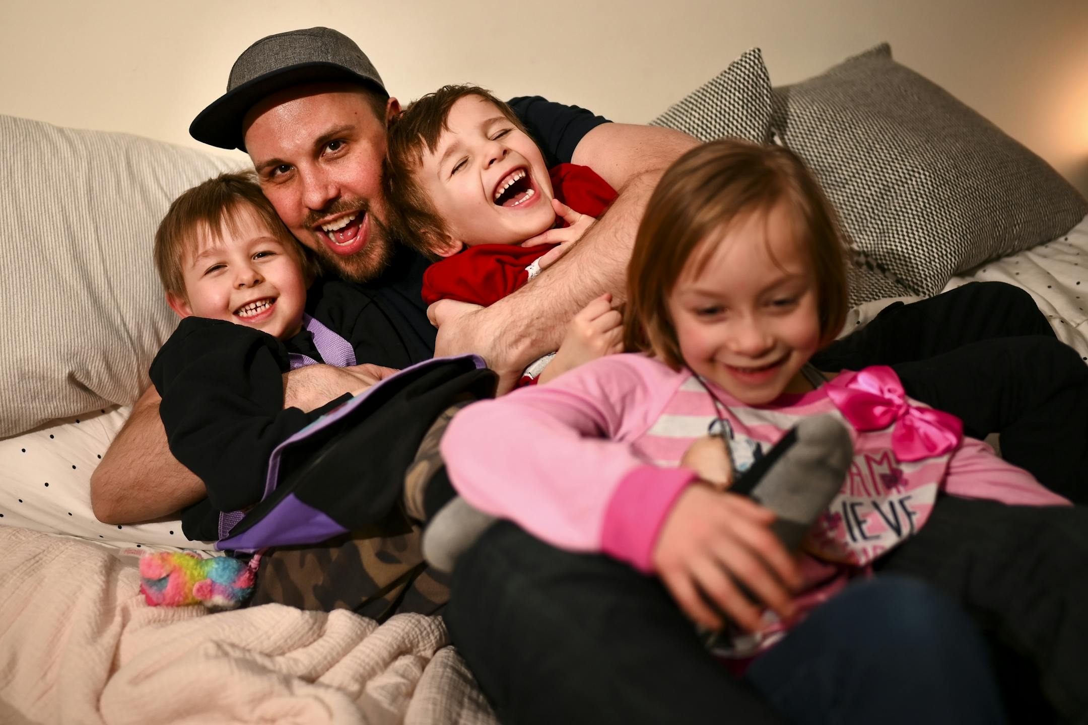 Aaron Mader was photographed with his children, from left, Lou and Cam, both 4, and Penny, 6, Tuesday night in their home.