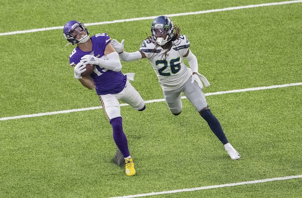 Minnesota Vikings' Adam Thielen (19) caught a 34-yard pass while defended by Seattle Seahawks' Shaquill griffin (26) in the first quarter.