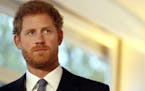 Britain's Prince Harry stands by a sign as he watches a short film at an International Mine Awareness Day reception at Kensington Palace in London, Tu