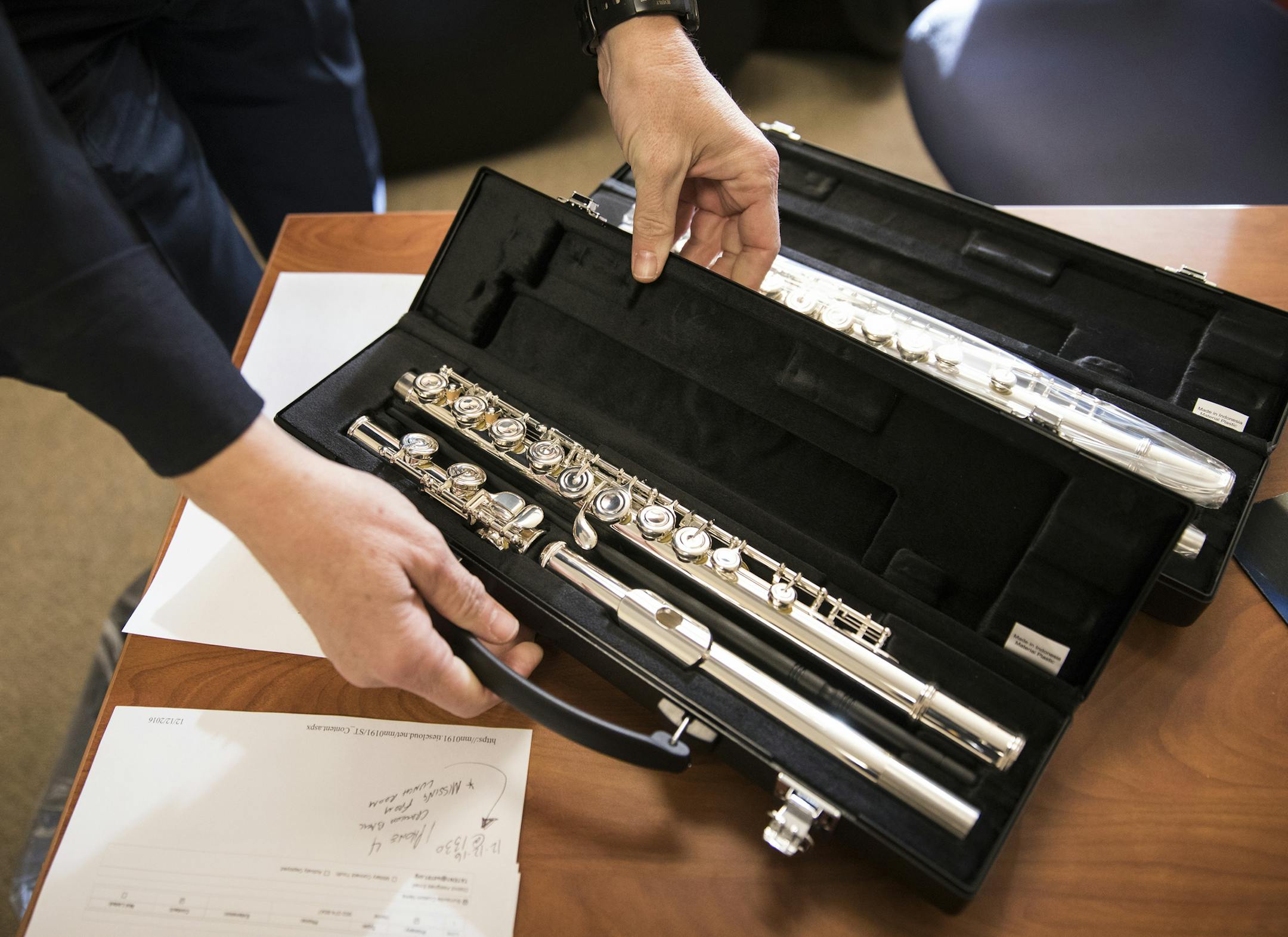 Officer Beverly Price shows off a donated flute inside her office at Nicollet Middle School in Burnsville] (Leila Navidi/Star Tribune) leila.navidi@startribune.com BACKGROUND INFORMATION: Officer Beverly Price looks through instrument donations in her office at Nicollet Middle School in Burnsville on Tuesday, December 13, 2016. Nicollet Middle School received donations of 15 musical instruments for band classes from the Manilow Music Project.