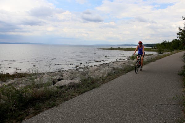 Margy Umhoefer of Sauk Centre, Minnesota, bikes along the shore of Little Traverse Bay on the Little Traverse Wheelway between Petoskey and Charlevoix