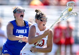 Maycie Neubauer (23) of Stillwater protects the ball and works past Grace Larson (7) of Minnetonka in a girls lacrosse state quarterfinal Tuesday in C