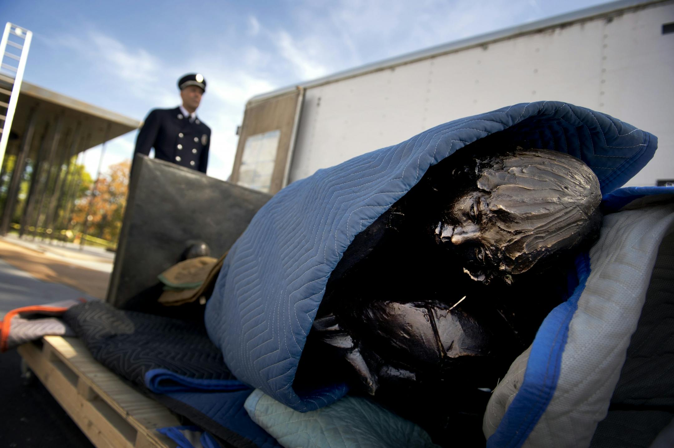 St. Paul Fire Capt. Bob Kippels stood over a statue to be dedicated Sunday as part of the Fallen Firefighter Memorial. The statue, a firefighter on a ladder holding a child, was last on display at the airport.