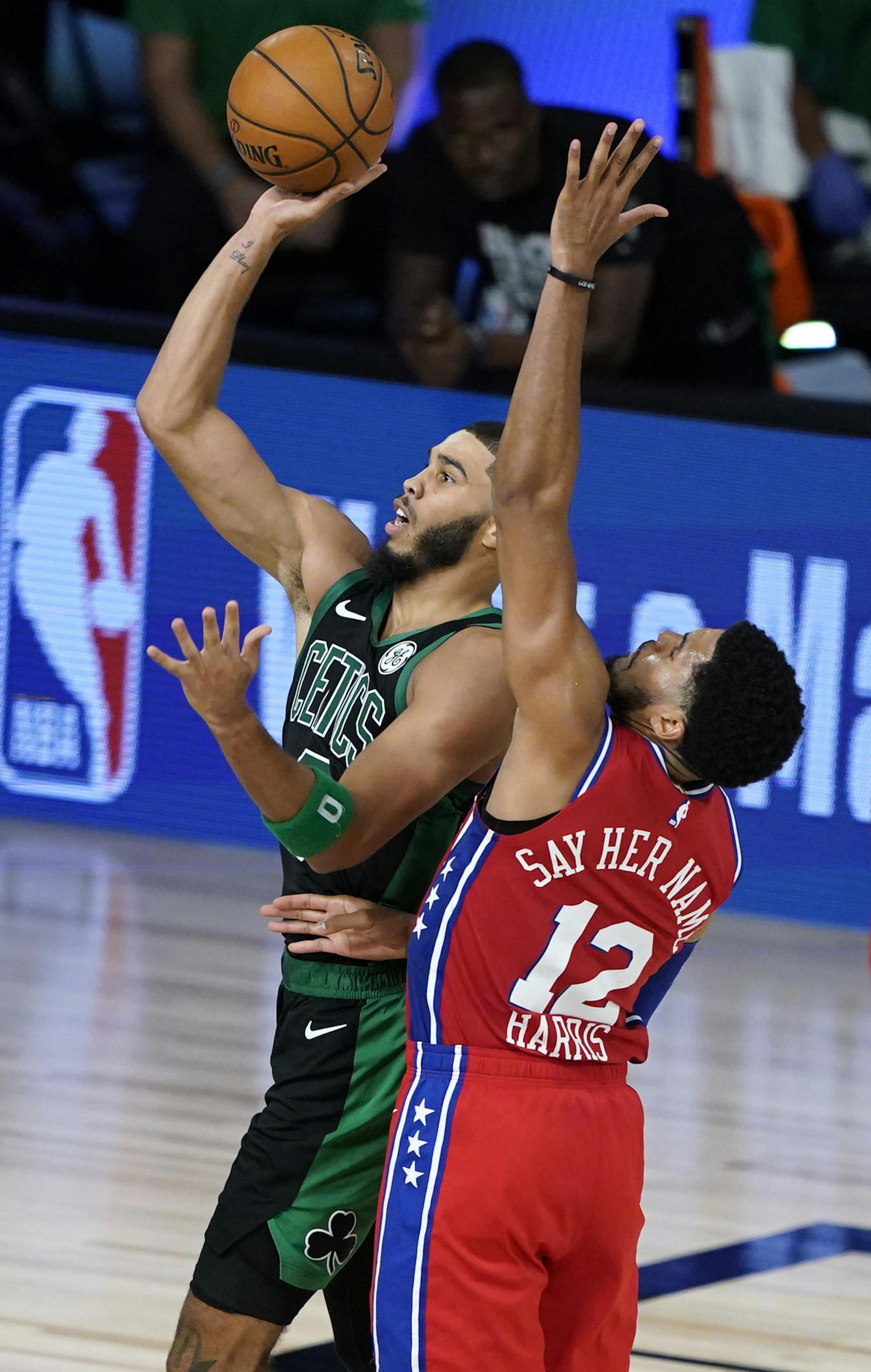 Boston Celtics' Jayson Tatum, center, shoots as Philadelphia 76ers' Tobias Harris (12) defends during the second half of an NBA basketball first round playoff game Monday, Aug. 17, 2020, in Lake Buena Vista, Fla. (AP Photo/Ashley Landis, Pool)