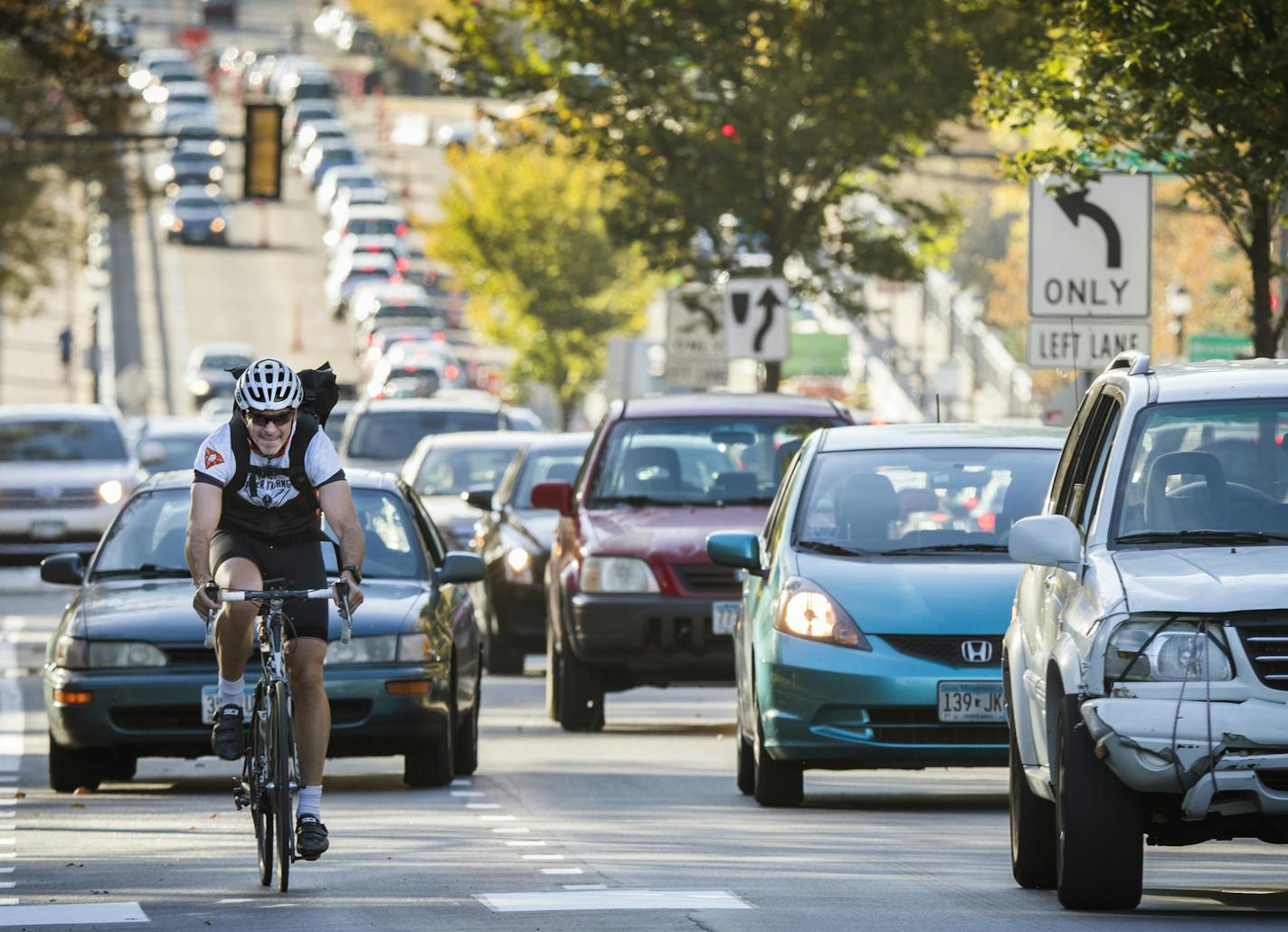 Cyclists and traffic move up Marshall Avenue eastbound in St. Paul during rush hour. ] LEILA NAVIDI &#xef; leila.navidi@startribune.com BACKGROUND INFORMATION: Cyclists and traffic move up Marshall Avenue eastbound in St. Paul during rush hour on Tuesday, October 17, 2017. New bike lanes are cropping up around the Twin Cities, creating a divide between cyclists who feel safer riding in a lane and motorists, residents and business owners frustrated by lost space for driving and parking. ORG XMIT: