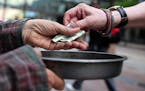 Edwin Schall got a dollar from a passerby as he held out a pan t get money for food along Nicollet Ave. ] (KYNDELL HARKNESS/STAR TRIBUNE) kyndell.hark