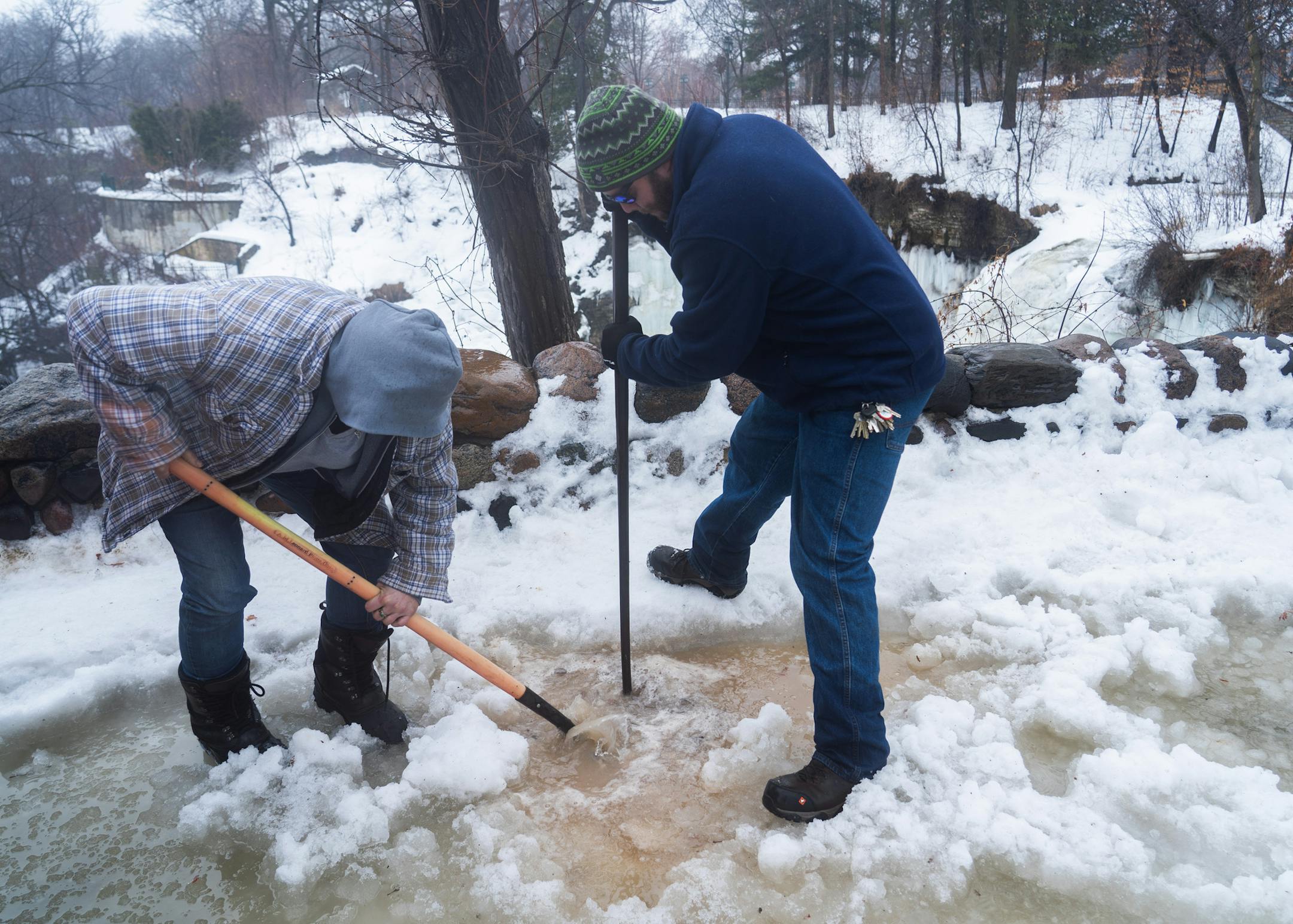 Working from memory and armed with shovels and picks, Minneapolis park keepers Jennifer Dennis and Ryan Susag have been working to clear drains packed with ice and snow at Minnehaha Falls all morning. ] MARK VANCLEAVE ¥ Rain and warm temperatures continued to melt an unusually deep snowpack across the Twin Cities on Wednesday, Mar 13, 2019.
