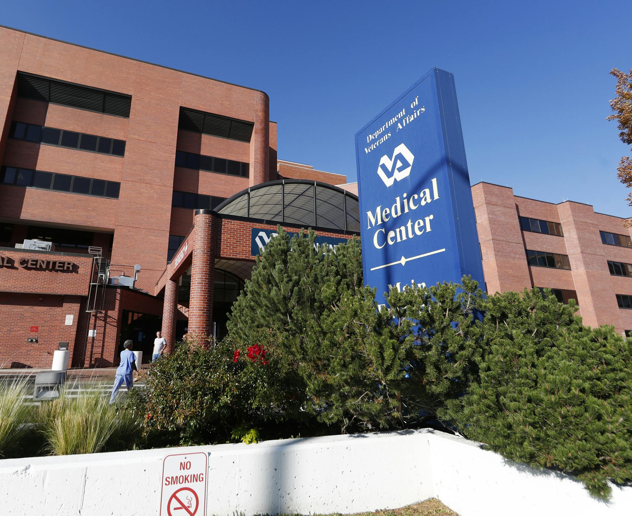 Blue sign says "Department of Veterans Affairs Medical Center" in front of brick building.