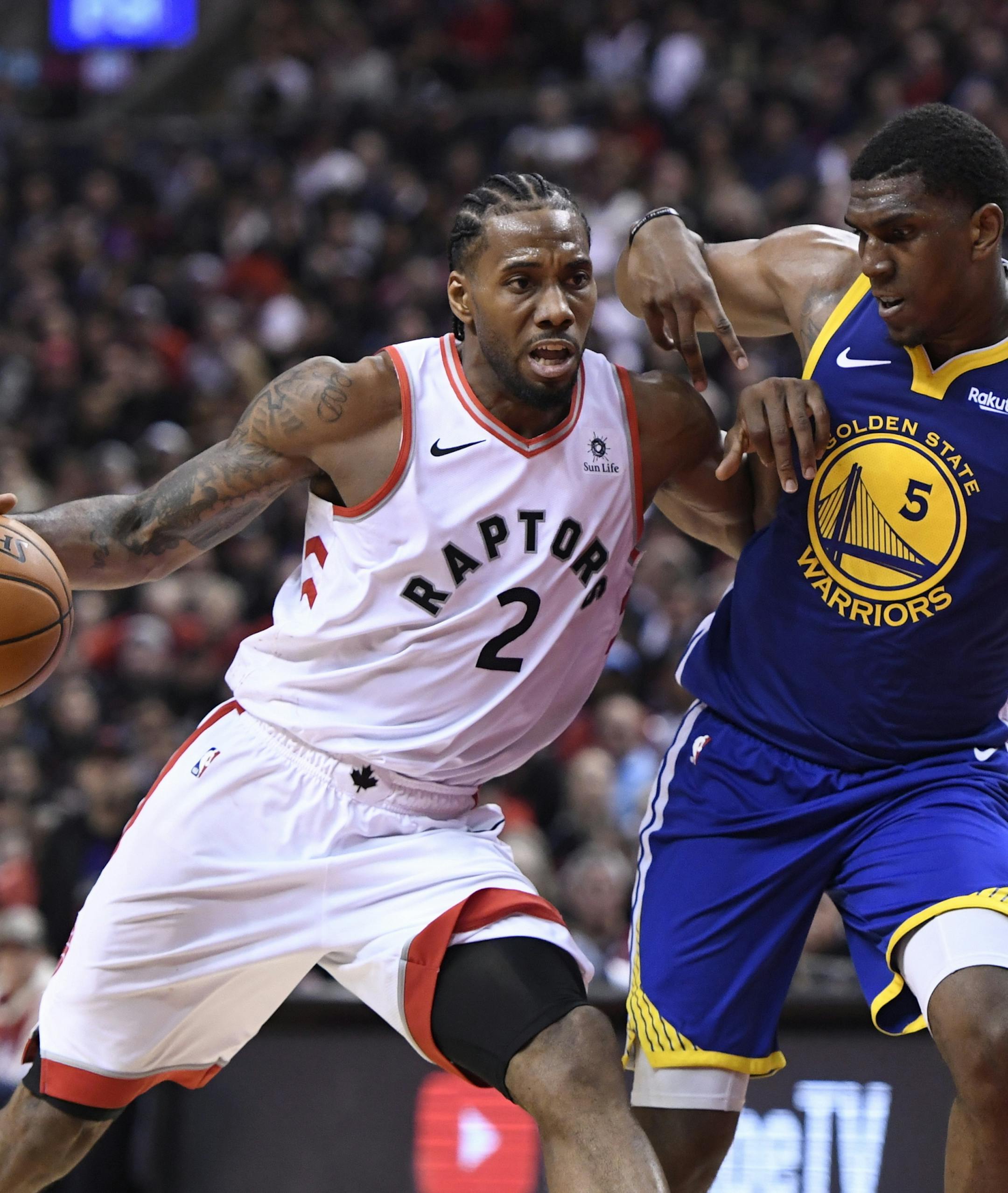 Toronto Raptors forward Kawhi Leonard (2) drives as Golden State Warriors center Kevon Looney (5) defends during the second half of Game 1 of basketball’s NBA Finals, Thursday, May 30, 2019, in Toronto. (Frank Gunn/The Canadian Press via AP)