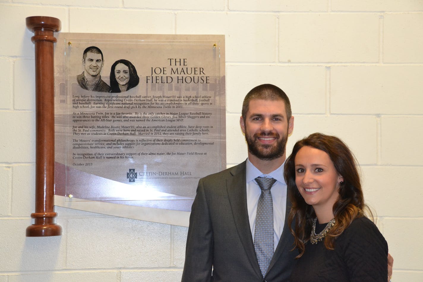 Joe and Maddie Mauer stand next to the plaque in their honor in the Cretin-Derham Hall fieldhouse.