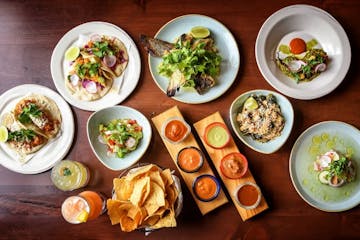 Clockwise from top left: Chicken Tinga tacos, Smelt tacos, the weekly fish special Grilled Halibut Collar, Grilled Octopus, Aguachile, Brussels Sprout