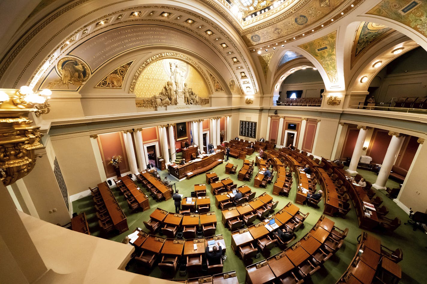 The Minnesota legislature meets in special session Monday, July 13, 2020, in St. Paul, Minn. Social distancing requires a small number of legislators in the House chamber. The rest participate remotely. (Glen Stubbe/Star Tribune via AP)