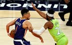 Timberwolves guard Josh Okogie, right, defends Phoenix guard Devin Booker during the second half of the Wolves’ 123-119 win Thursday. (AP Photo/Rick
