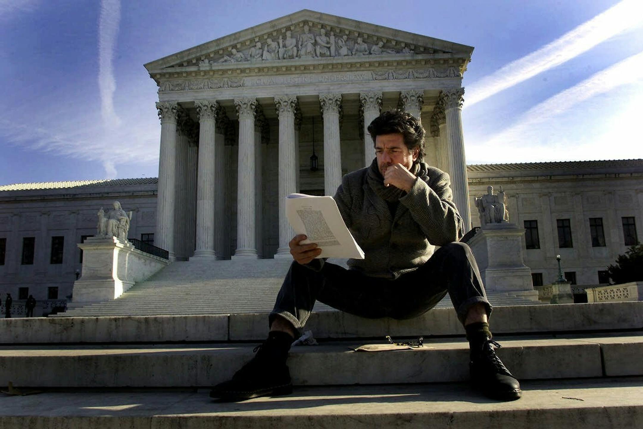 (NYT23) WASHINGTON -- Dec. 13, 2000 -- ELECT-SCENE-COX-1 -- On the day after the U.S. Supreme Court effectively ended the seemingly endless presidential election, the nation's capital awoke to a new political reality. While there was widespread relief that it was all nearly over, supporters of Vice President Al Gore said their passions would not subside for four years. Jack Charney of Santa Fe, N.M., a Gore supporter, sits on the steps of the Supreme Court Wednesday morning reading the historic