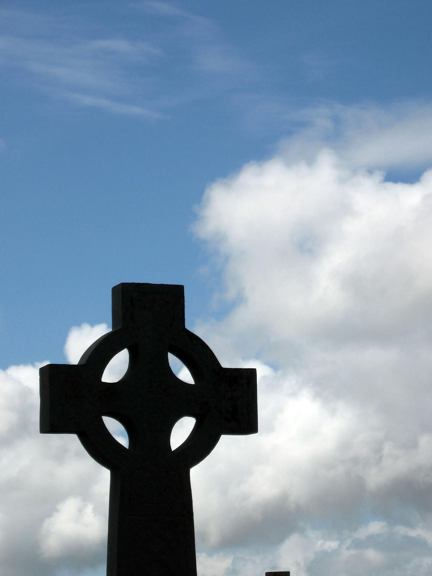 A traditional Celtic cross stands atop a hill near Donegal Bay.