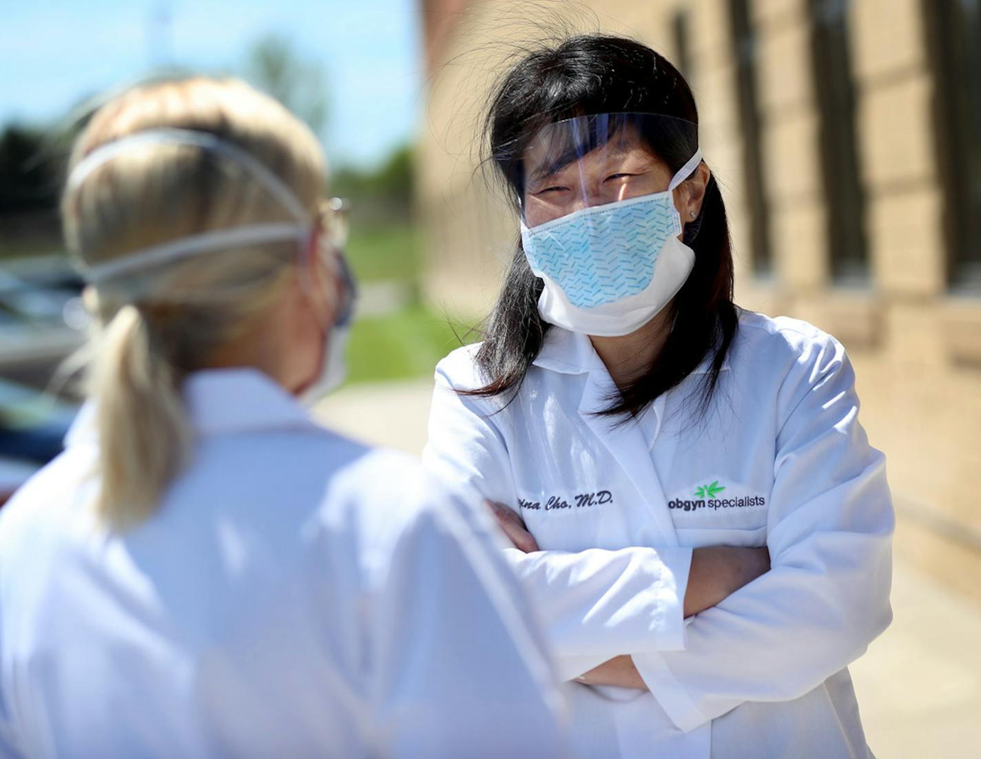 Dr. Regina Cho, an OB-GYN specialist at M Health Fairiview Clinic, right, chats with Kelsey Alexander, a PA at M Health Fairiview Clinic, prior to the start of curbside prenatal care visits on May 15 in Burnsville.