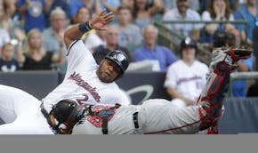 Twins catcher Bobby Wilson tagged out the Brewers' Jesus Aguilar at home during the first inning Monday.