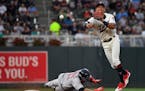 Boston Red Sox third baseman Rafael Devers (11) was out at second as Minnesota Twins shortstop Ehire Adrianza (16) turned a double play to first off a