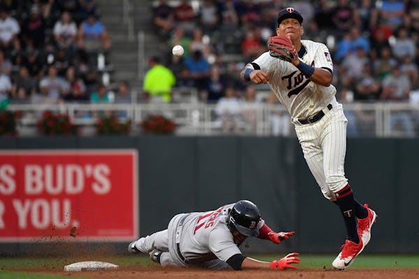 Boston Red Sox third baseman Rafael Devers (11) was out at second as Minnesota Twins shortstop Ehire Adrianza (16) turned a double play to first off a