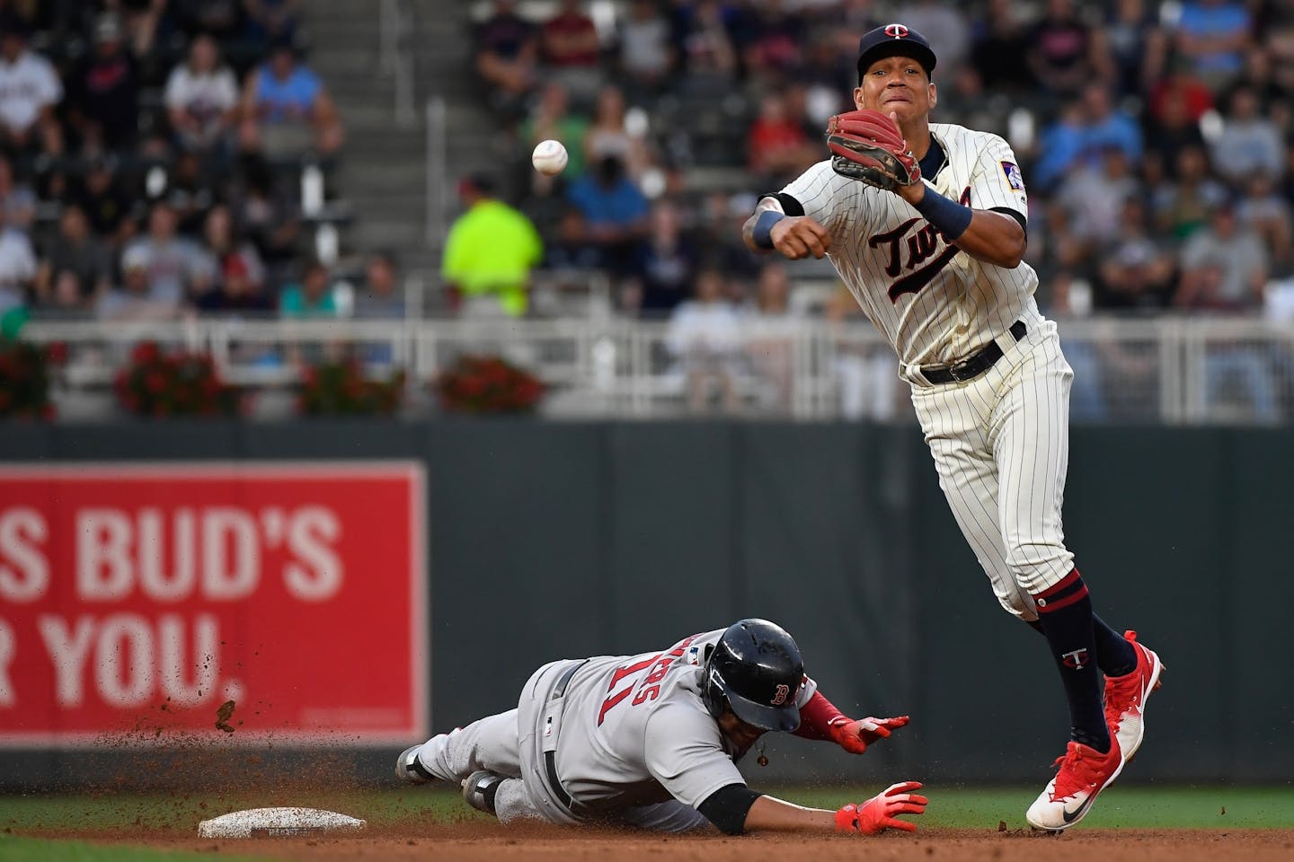 Boston Red Sox third baseman Rafael Devers (11) was out at second as Minnesota Twins shortstop Ehire Adrianza (16) turned a double play to first off a grounder by Boston Red Sox second baseman Brock Holt (12) in the top of the fourth inning.