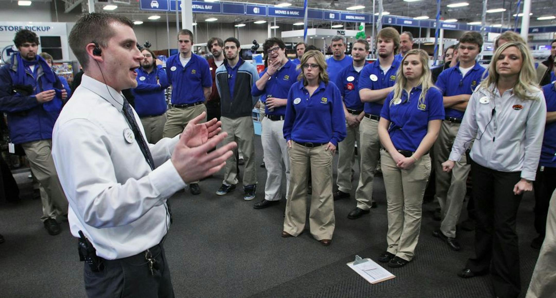 Profile of Mike Ersfeld, general manager of a Best Buy store in Eden Prairie, as copes with the pressure of Black Friday shopping. Ersfeld hands out store maps to customers waiting in line outside the store, greets them as they enter at midnight, and answers their product questions on the sales floor. Ersfeld, left, gave a pep talk to his sales staff before the doors opened.(MARLIN LEVISON/STARTRIBUNE(mlevison@startribune.com