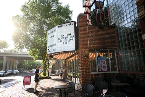 Theater manager Andy Windels changes the marquee Friday, July 28, 2023, at the Main Cinema in Minneapolis. Oppenheimer and Barbie's blockbuster releases could show that the demand for movie theaters isn't dead due to streaming services and the pandemic.