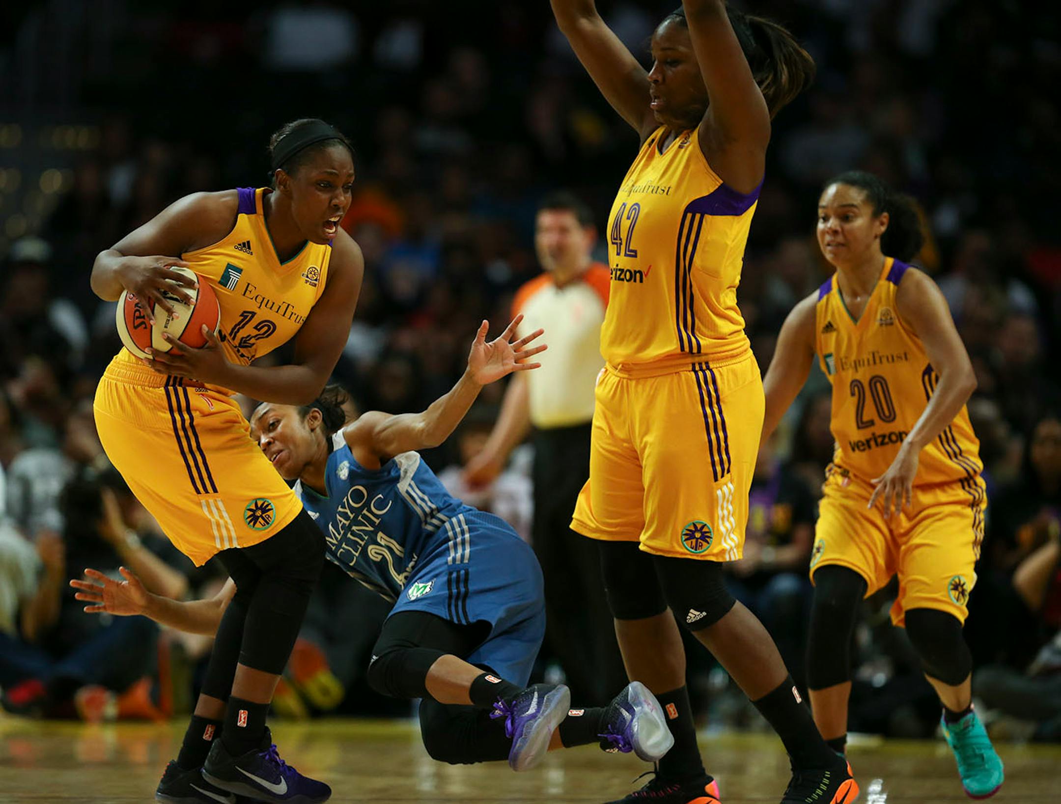 Los Angeles Sparks guard Chelsea Gray (12) took the ball away from Minnesota Lynx guard Renee Montgomery (21) in the fourth quarter as she and Los Angeles Sparks center Jantel Lavender (42) guarded her.