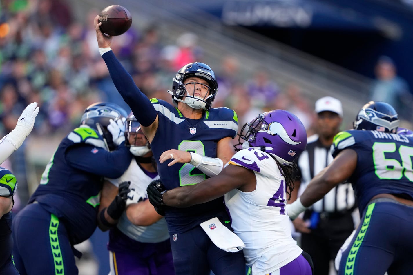 Seattle Seahawks quarterback Drew Lock, middle, is hit by Minnesota Vikings linebacker Luiji Vilain during the first half of an NFL preseason football game in Seattle, Thursday, Aug. 10, 2023. (AP Photo/Lindsey Wasson)