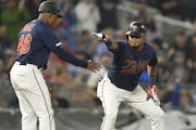 Minnesota Twins second baseman Luis Arraez (2) celebrated with third base coach Tony Diaz (46) after Arraez tripled in the bottom of the fourth inning