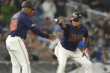 Minnesota Twins second baseman Luis Arraez (2) celebrated with third base coach Tony Diaz (46) after Arraez tripled in the bottom of the fourth inning