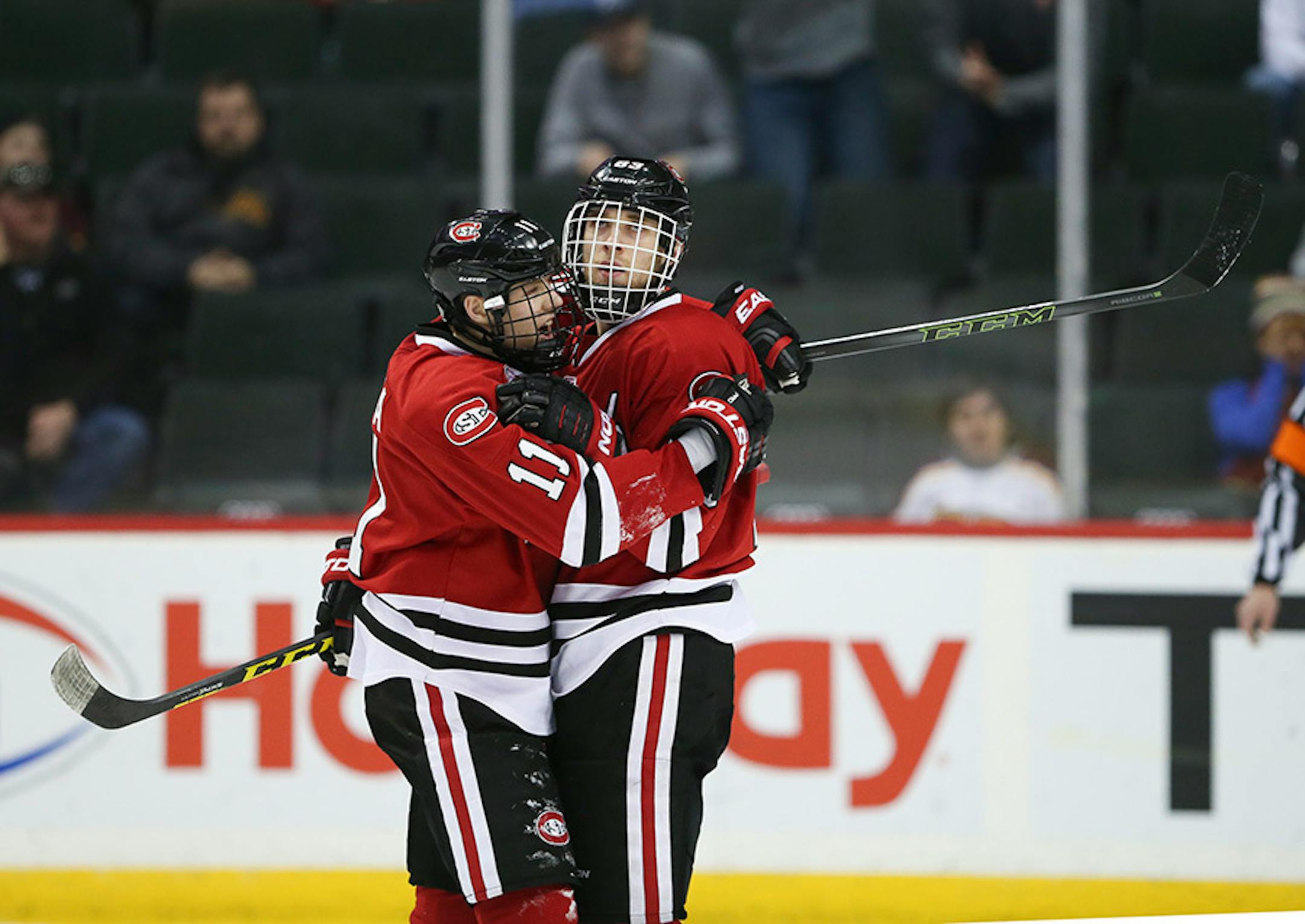 Huskies forward Kalle Kossila (11) congratulated Huskies forward Patrick Russell on his second period Sunday afternoon.