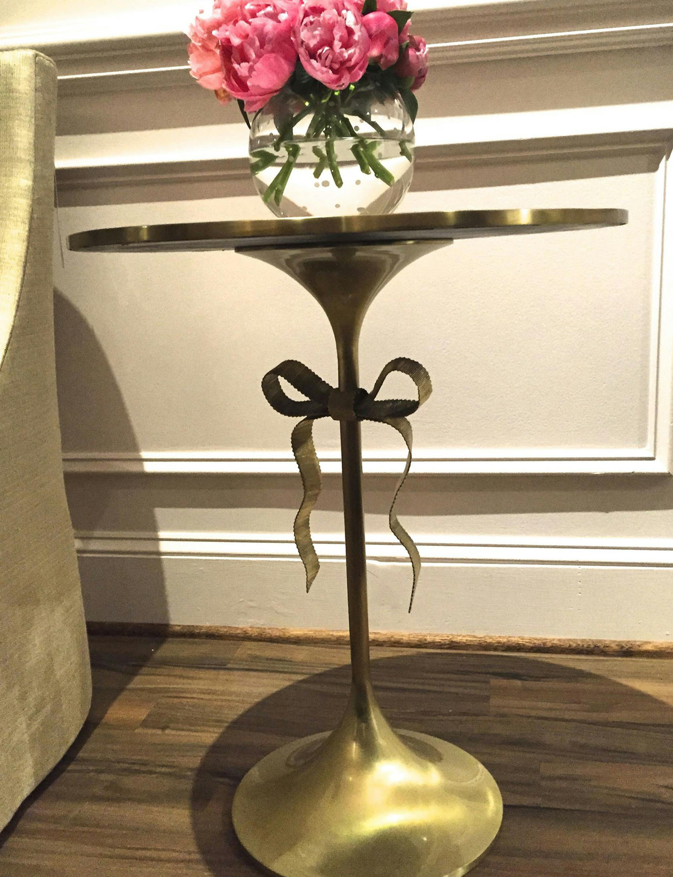 Ellery side table by Kate Spade Home in polished brass with signature bow and cream glass top. (Patricia Sheridan/Pittsburgh Post-Gazette/TNS) ORG XMIT: 1176021