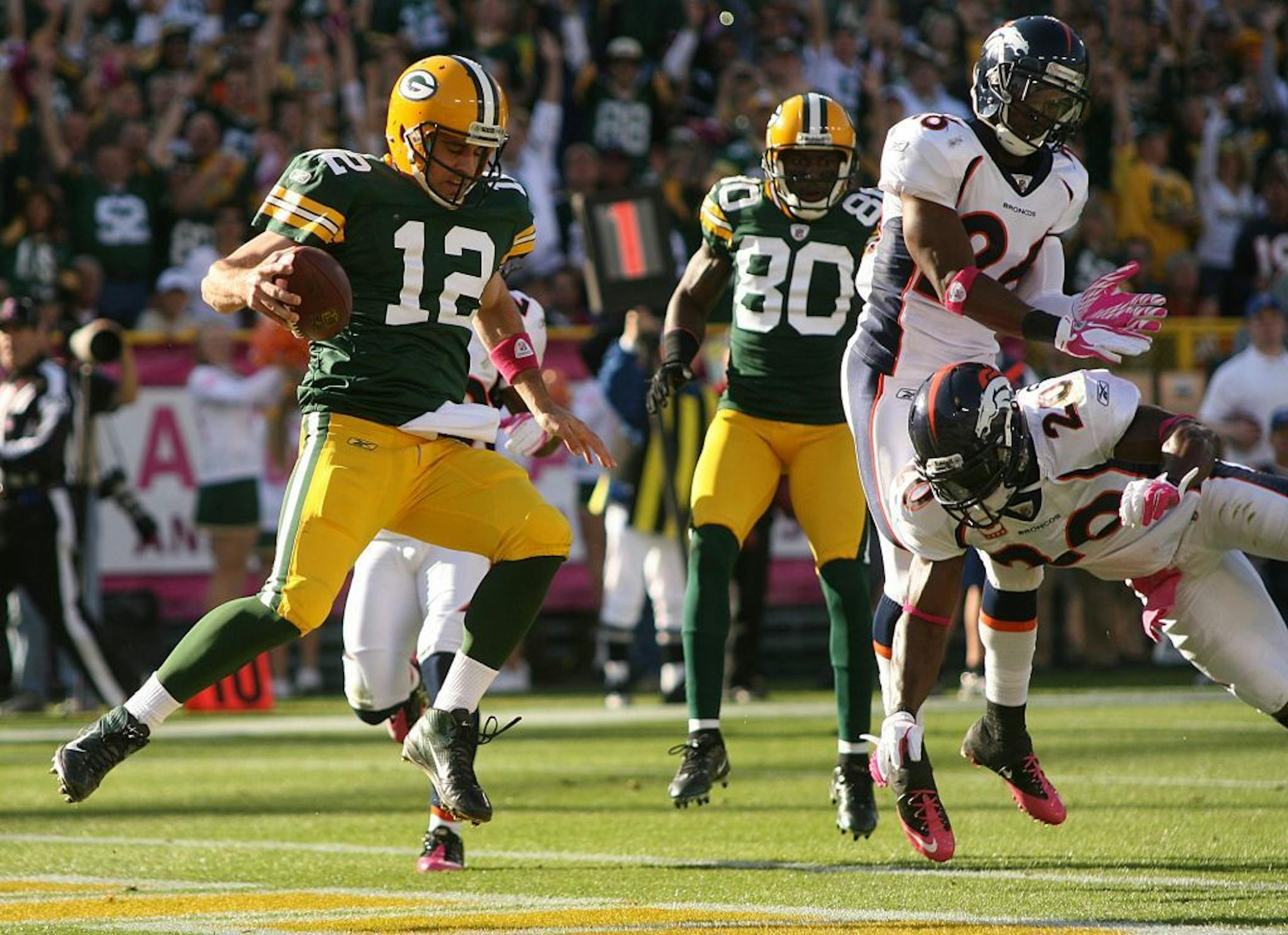 Green Bay Packers quarterback Aaron Rodgers (12) runs in for a touchdowns in the second quarter of an NFL football game against the Denver Broncos at Lambeau Field in Green Bay, Wis., Sunday, Oct. 2, 2011. Green Bay defeated Denver 49-23.