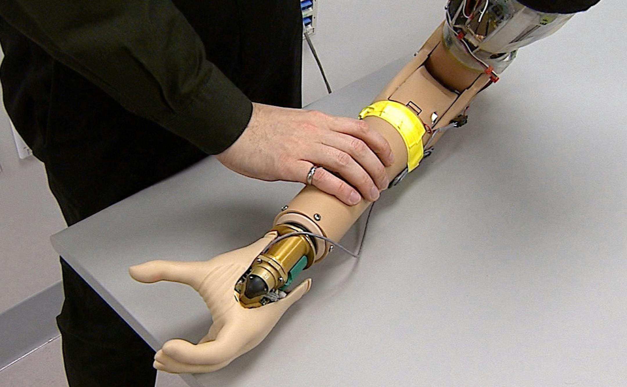 A Cleveland Clinic Lerner Research Institute researcher manipulates a prosthetic arm. (Cleveland Clinic)