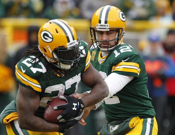 Green Bay Packers quarterback Aaron Rodgers hands the ball off to running back Eddie Lacy (27) during the first half of an NFL divisional playoff foot
