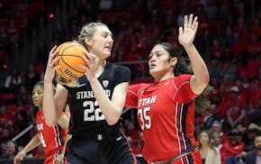 Stanford forward Cameron Brink (22) posts up against Utah forward Alissa Pili (35) in February 2023.