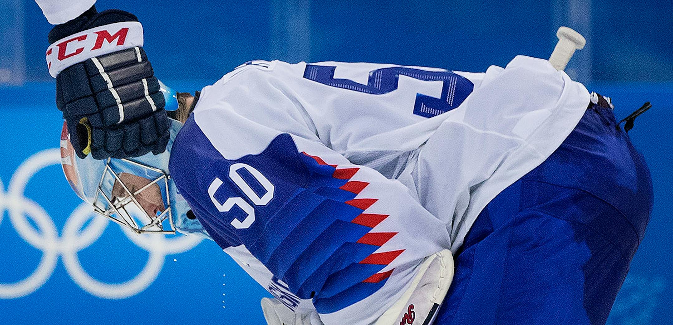 Slovakia goalie Jan Laco (50) was consoled by teammate Dominik Granak (51) after giving up his fifth goal of the game.