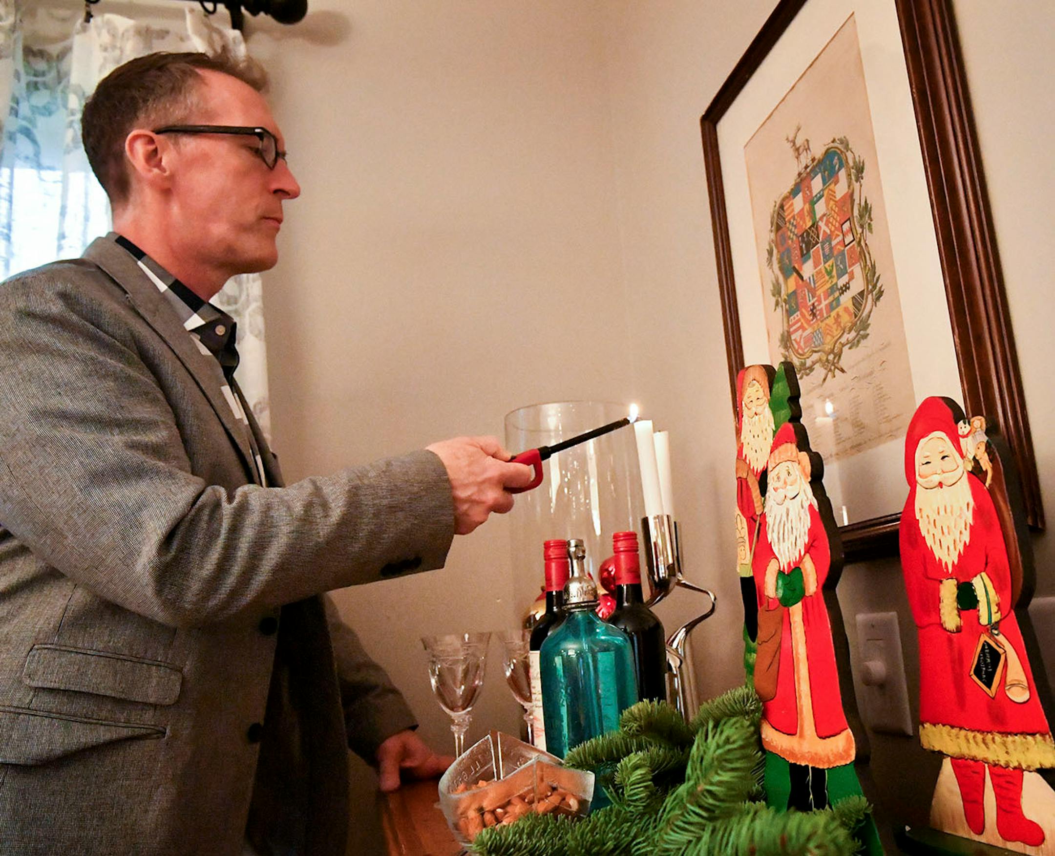Interior designer Jay Nuhring lights the candles on a beverage bar holiday vignette.