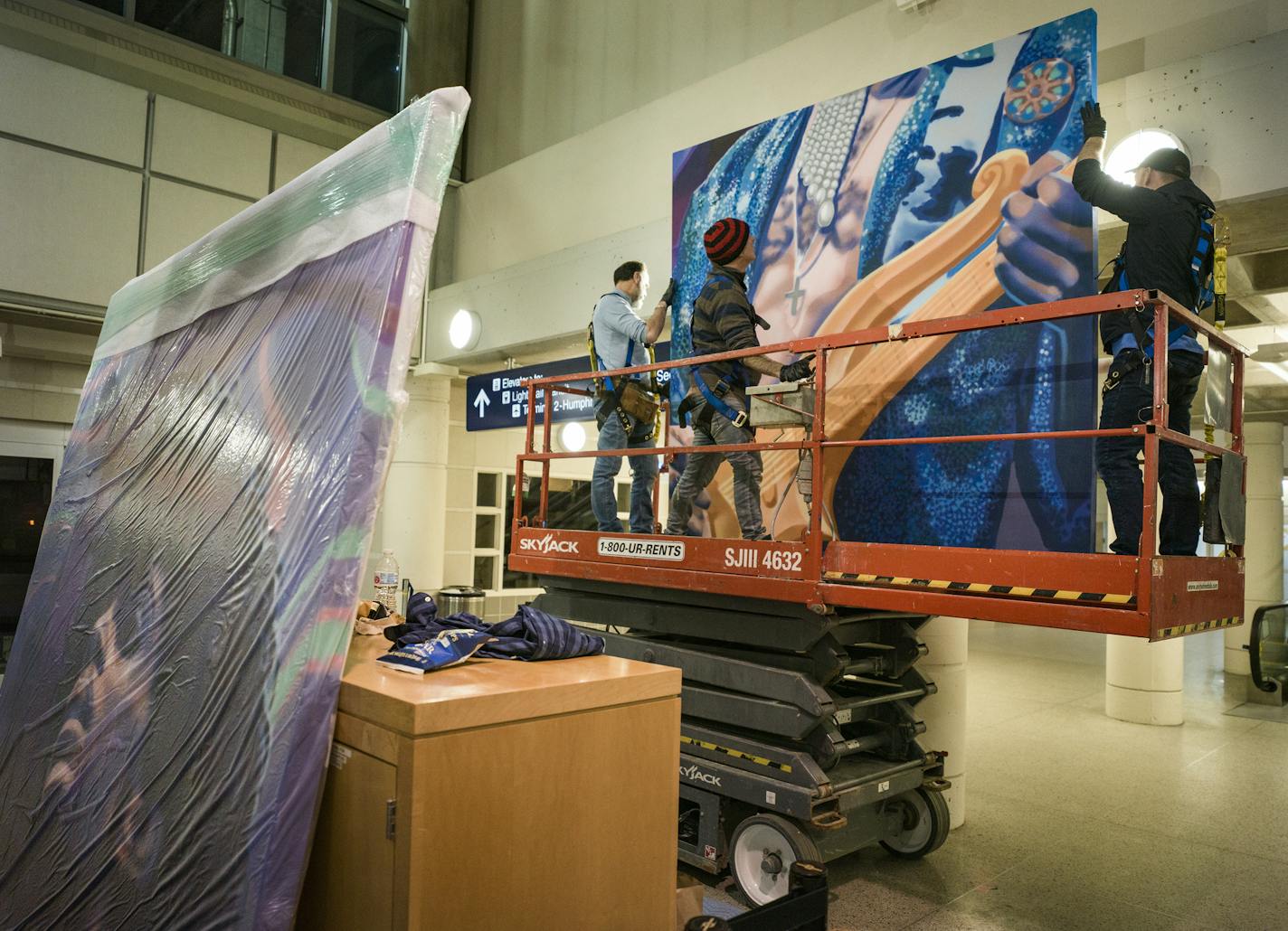 Workers got ready to affix one of six panels to a wall at the Tram level of Minneapolis-St. Paul International Airport's (MSP) Terminal 1. The work, entitled "I Would Die 4 U," was created in 2017 by Minneapolis-based artist Rock Martinez, an international aerosol artist ] Fans of locally born and raised artist Prince will have another reason to celebrate when a large, 16-foot by 24-foot mural of the music legend will be installed on the Tram level of Minneapolis-St. Paul International Airport's