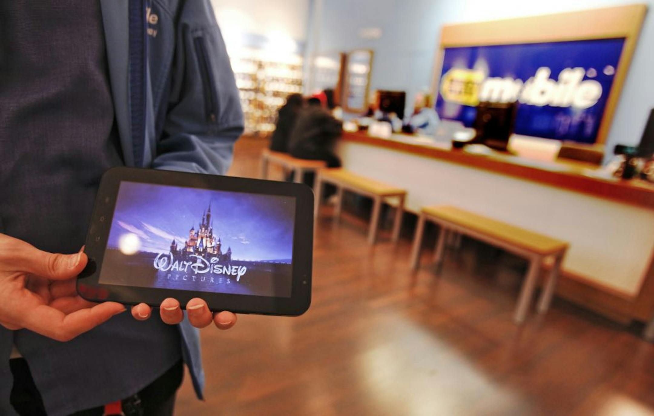 Best Buy sale lead Bridget Oswald shows off a Samsung Galaxy tablet, a portable internet device, at the Best Buy Mobie Store to customers walking by in the Maplewood Mall.