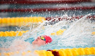 Eden Prairie senior Luke Logue swims the back stroke in a heat of the 200 IM during the preliminaries of the Class 2A boys swimming state meet Friday,