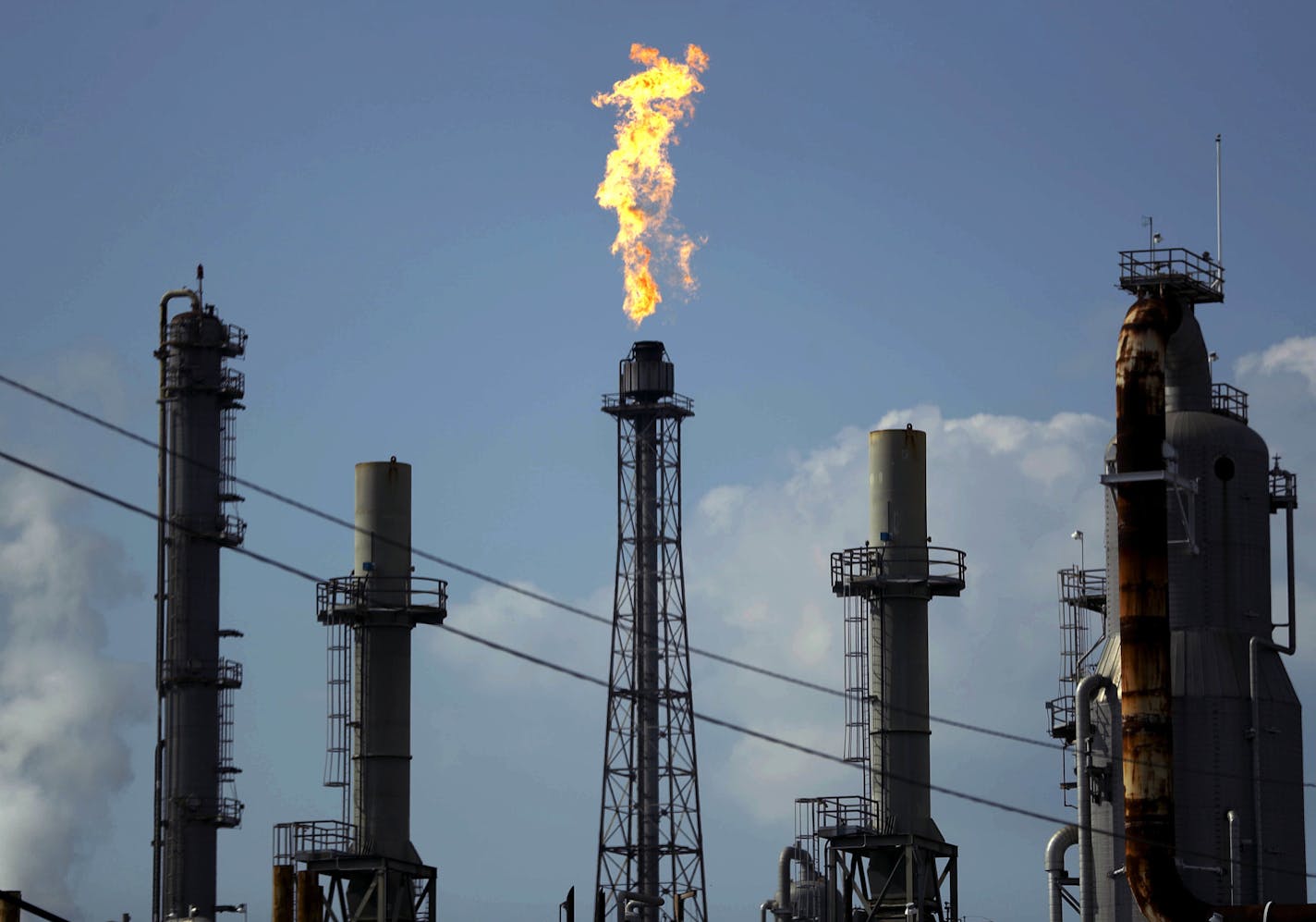 FILE - In this Thursday, Aug. 31, 2017, file photo, a flame burns at the Shell Deer Park oil refinery in Deer Park, Texas. Oil prices are plunging Sunday, March 8, 2020, amid worries that an OPEC dispute will lead a virus-weakened economy to be awash in an oversupply of crude. (AP Photo/Gregory Bull, File)