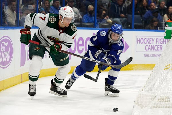 Minnesota Wild center Nico Sturm (7) moves the puck ahead of Tampa Bay Lightning center Anthony Cirelli (71) during the third period of an NHL hockey 