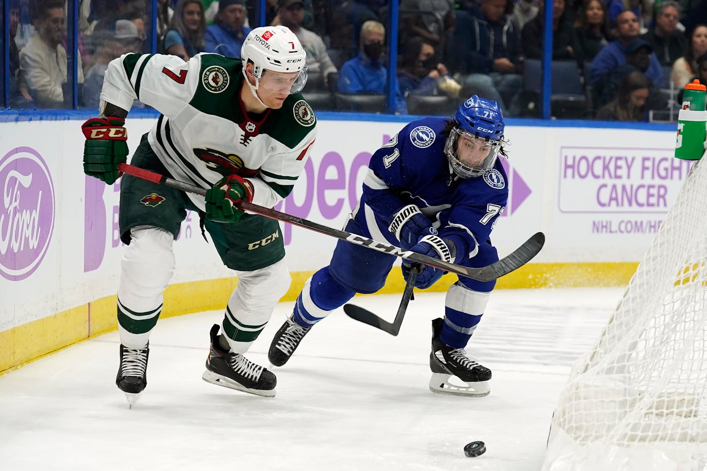 Minnesota Wild center Nico Sturm (7) moves the puck ahead of Tampa Bay Lightning center Anthony Cirelli (71) during the third period of an NHL hockey game Sunday, Nov. 21, 2021, in Tampa, Fla. (AP Photo/Chris O'Meara)