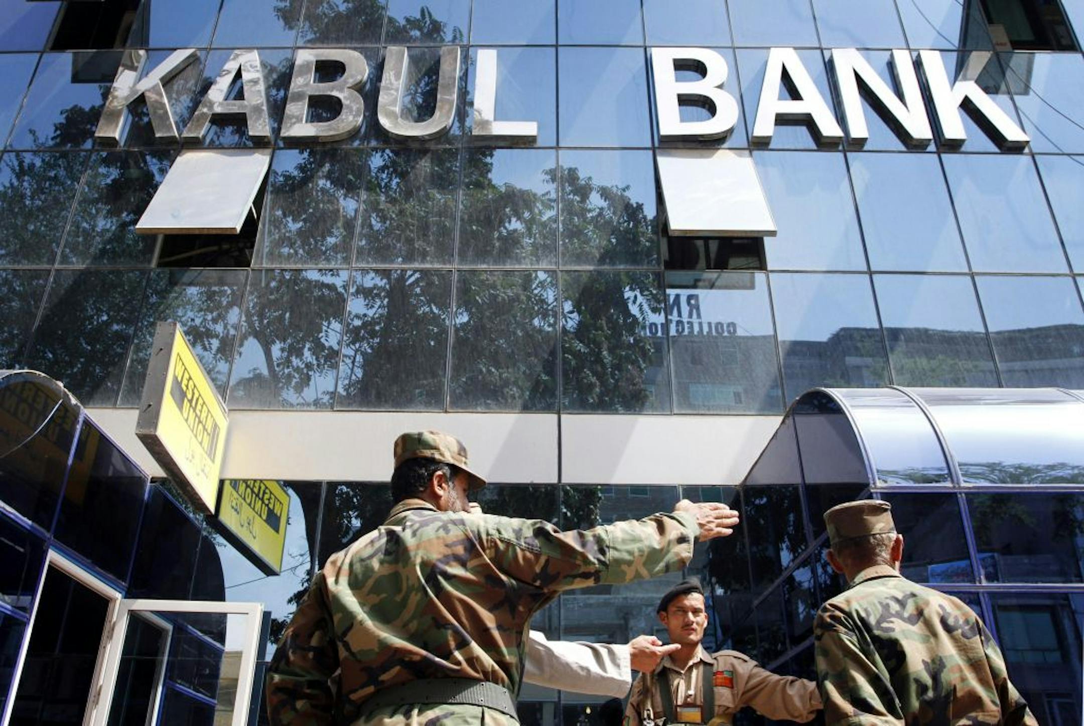 Afghan soldiers stood outside the main Kabul Bank office in 2010. The bank "was nothing but a fraud," a report released Wednesday said.