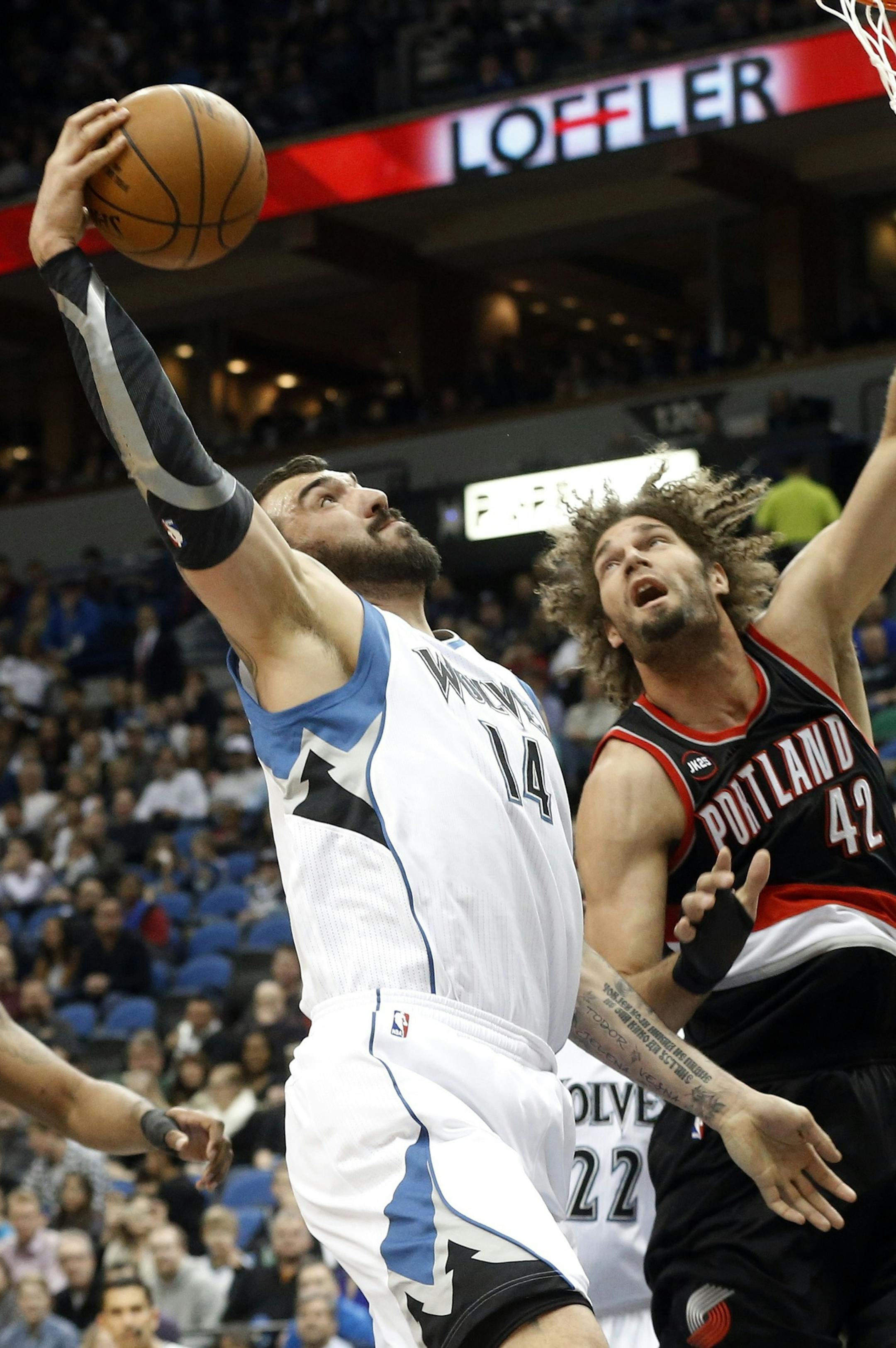 Minnesota Timberwolvesí Nikola Pekovic, right, of Montenegro, lays the ball up as Portland Trail Blazersí Robin Lopez defends in the first quarter of an NBA basketball game, Saturday, March 7, 2015, in Minneapolis. (AP Photo/Jim Mone) ORG XMIT: MIN2015030721160974