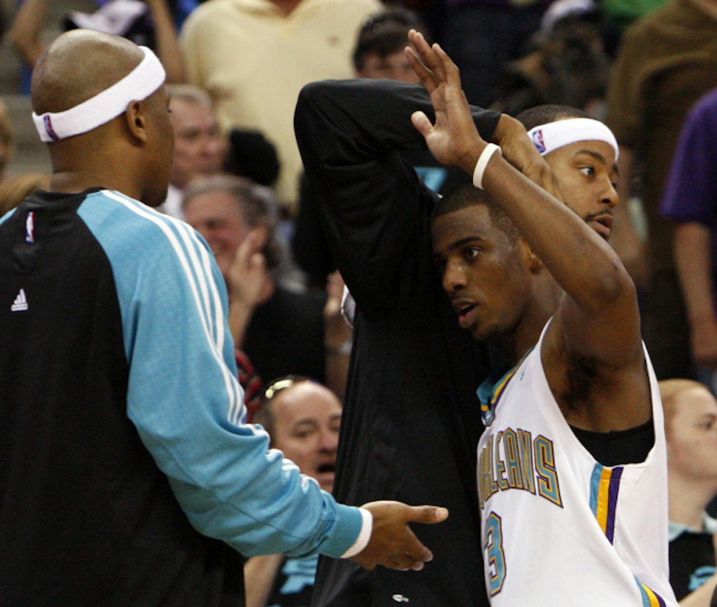 New Orleans Hornets guards Bonzi Wells, left, and Morris Peterson, right rear, congratulate teammate Chris Paul, front right, as he leaves the game during the final minutes of a basketball game against the Golden State Warriors in New Orleans, Sunday, April 6, 2008. Paul had 16 points and a triple-double as the Hornets won 108-96.