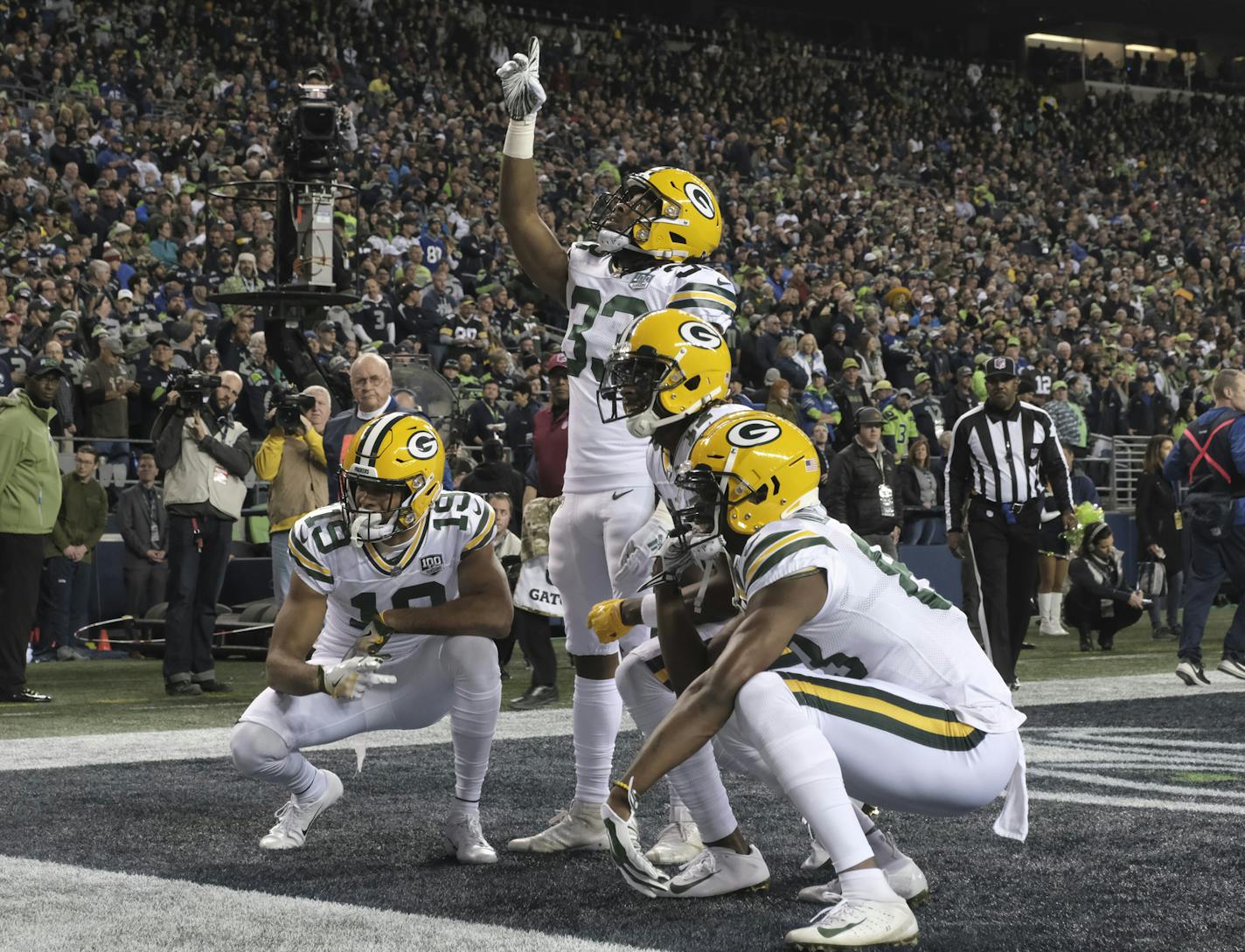 Green Bay Packers running back Aaron Jones (33) takes part in a touchdown celebration with teammates after he scored a touchdown in the first half of an NFL football game against the Seattle Seahawks, Thursday, Nov. 15, 2018, in Seattle. (AP Photo/Stephen Brashear)