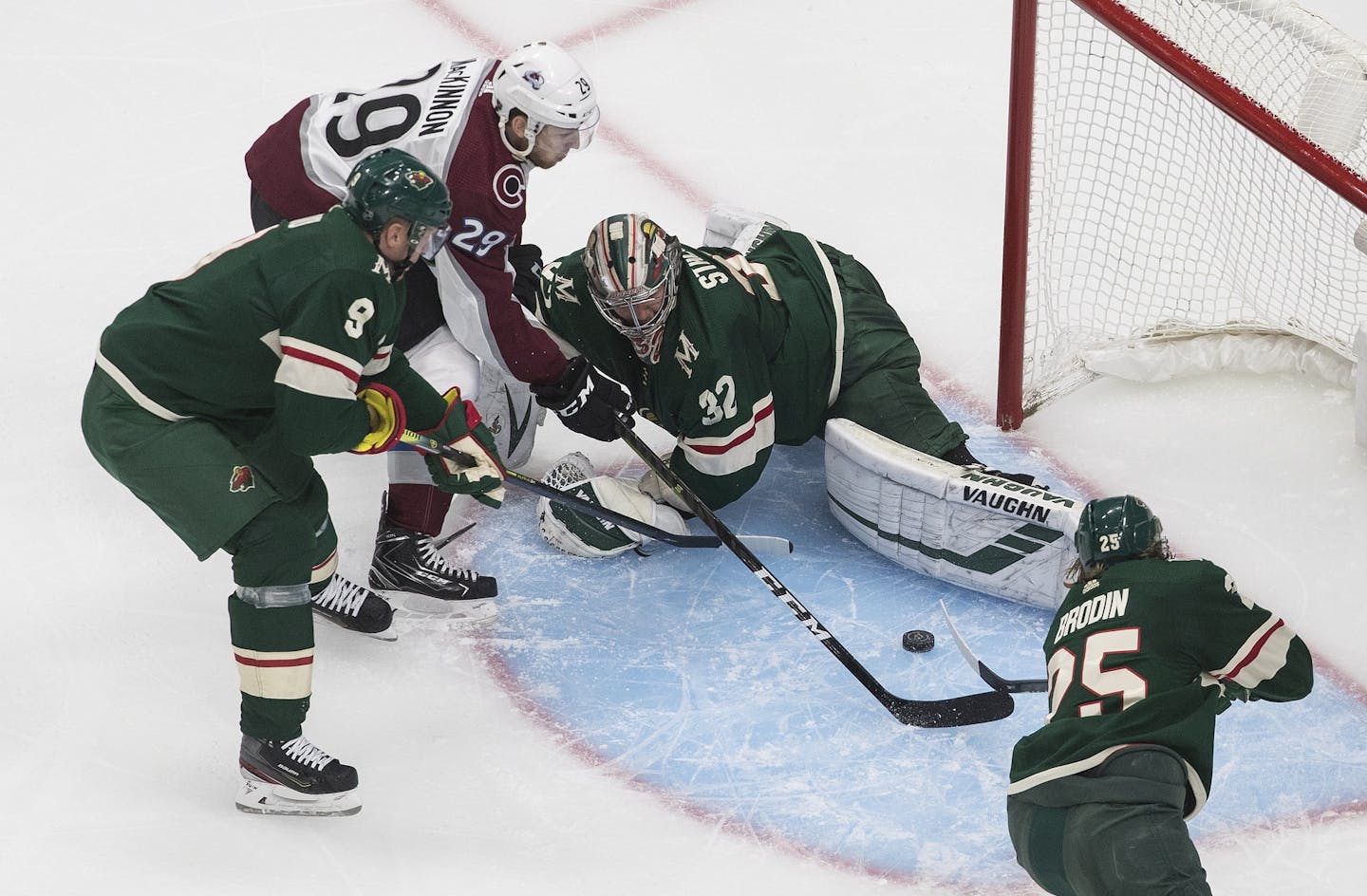 Colorado Avalanche's Nathan MacKinnon (29) is stopped by Minnesota Wild goalie Alex Stalock (32) as Mikko Koivu (9) and Jonas Brodin (25) defend during the second period of an exhibition NHL hockey game Wednesday, July 29, 2020 in Edmonton, Alberta.