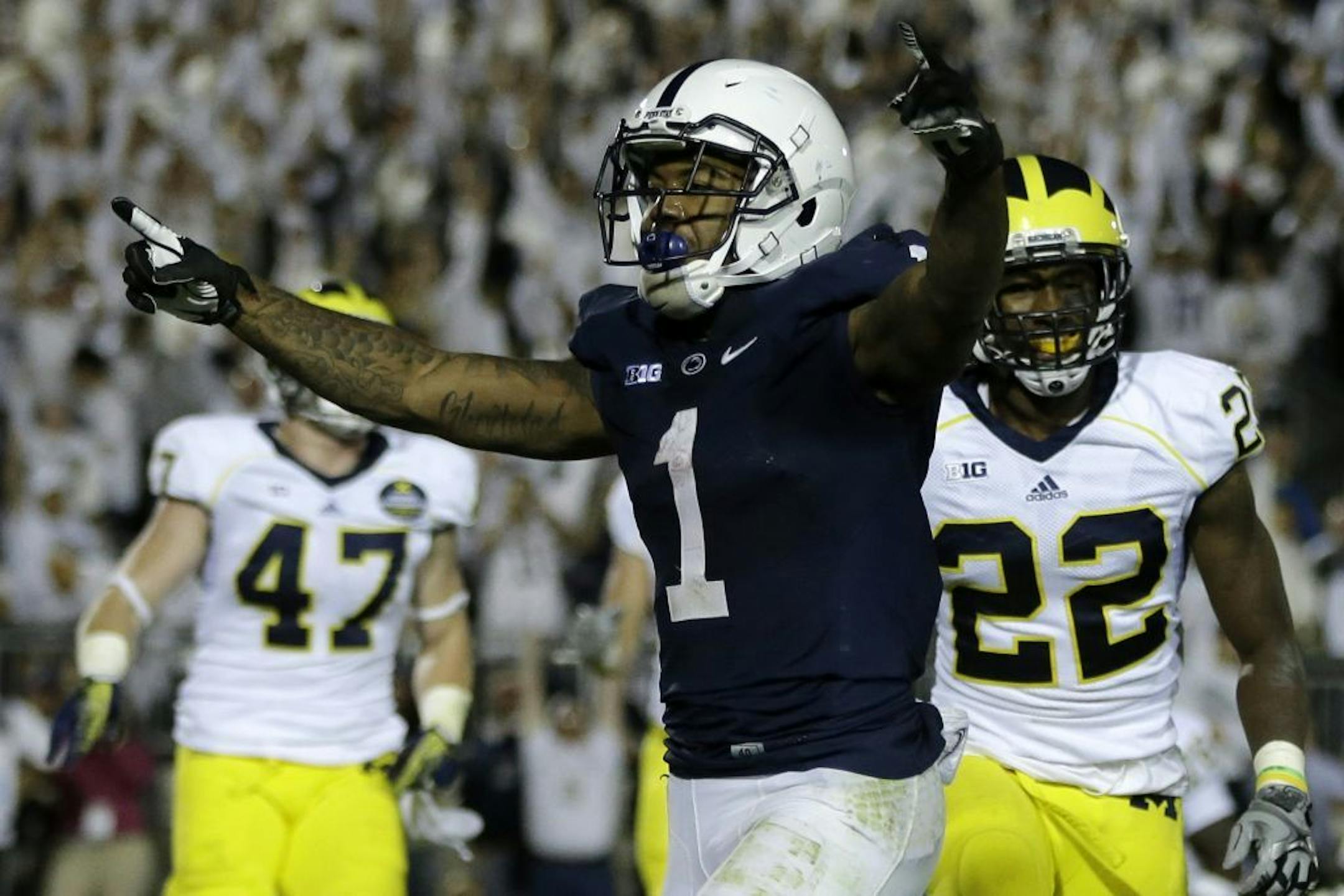 Penn State running back Bill Belton (1) celebrates in the end zone after scoring past Michigan safety Jarrod Wilson (22) to seal a 43-40 win over Michigan in the fourth overtime period of an NCAA college football game in State College, Pa., Saturday, Oct. 12, 2013. It was the first loss of the season for Michigan.